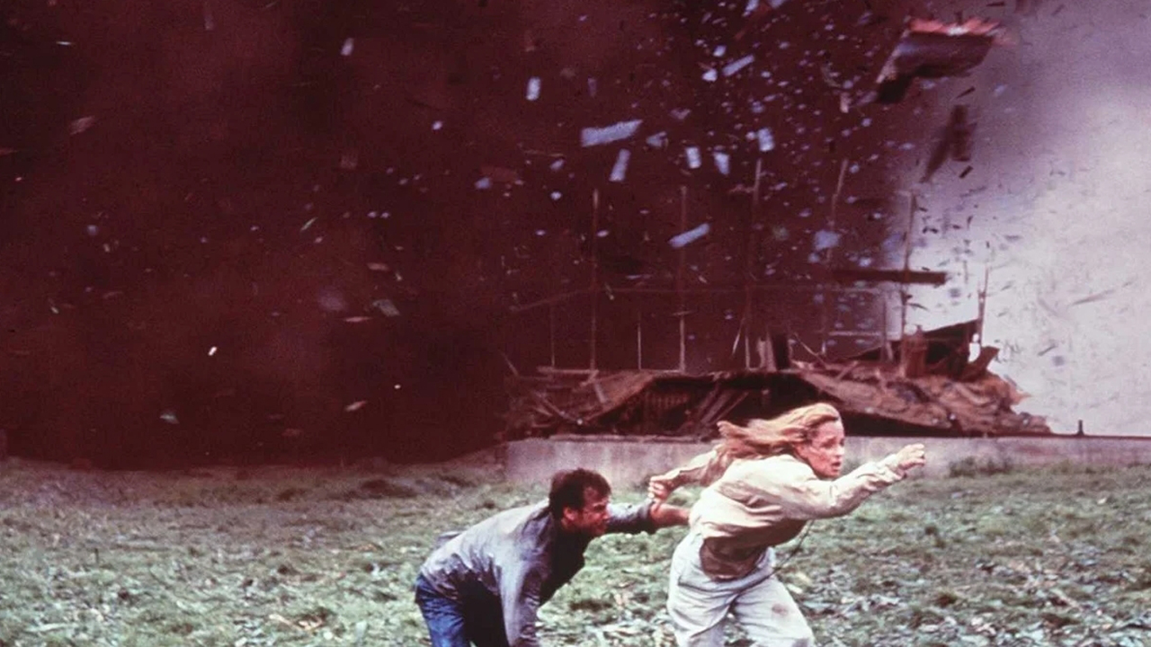 A man and a woman run from a tornado in this still from the movie Twister