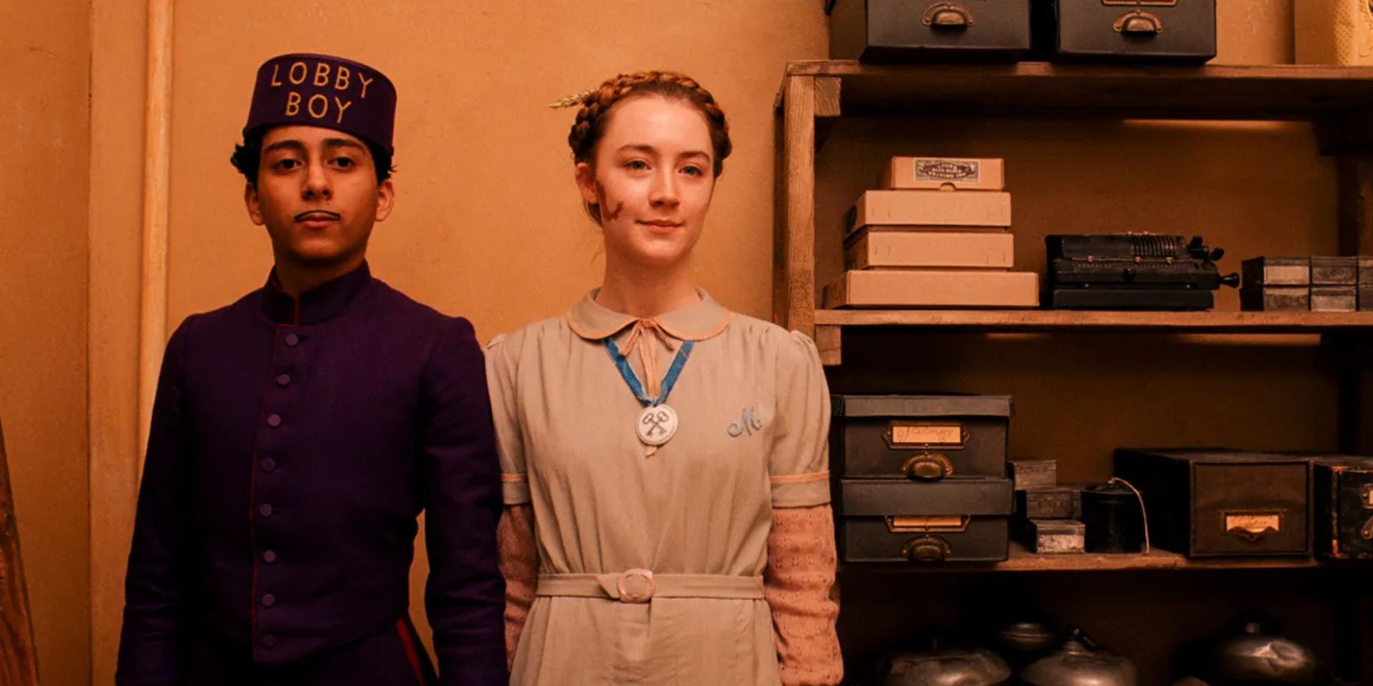 Tony Revolori and Saoirse Ronan holding hands at the Grand Budapest Hotel